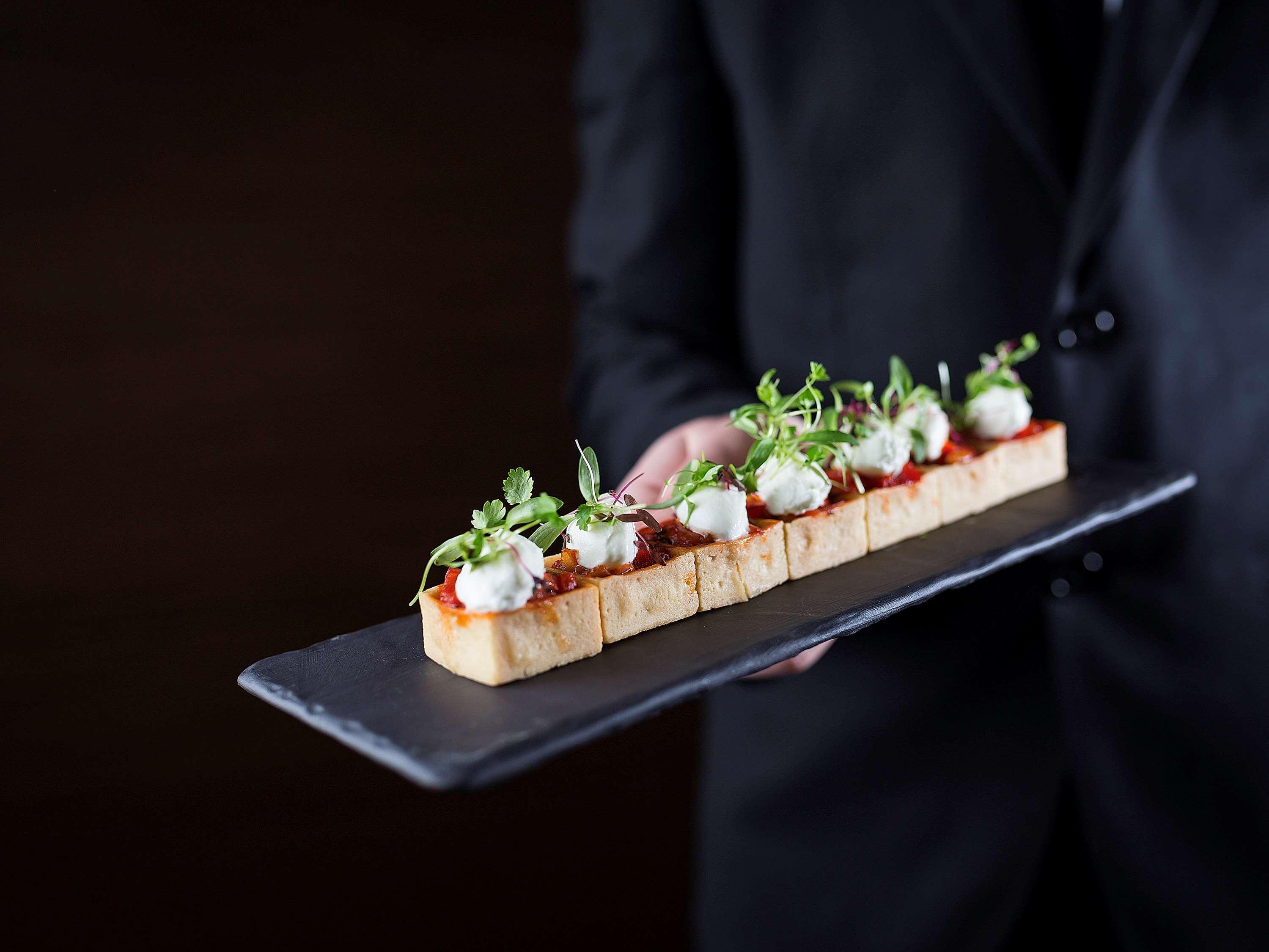 Pullman Sydney Olympic Park Hotel Exterior photo A server holding a plate of finger food