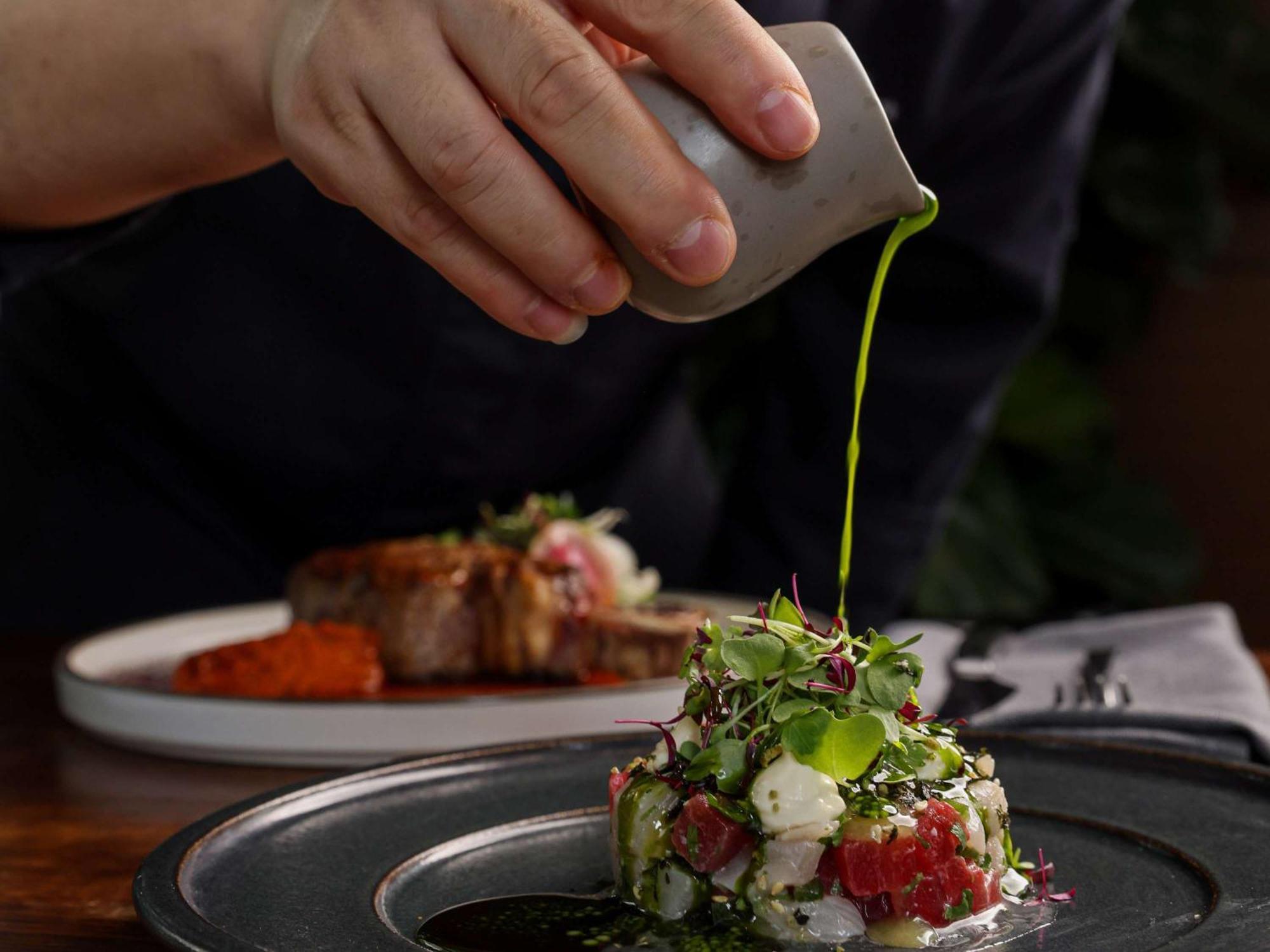 Pullman Sydney Olympic Park Hotel Exterior photo A chef seasoning a dish